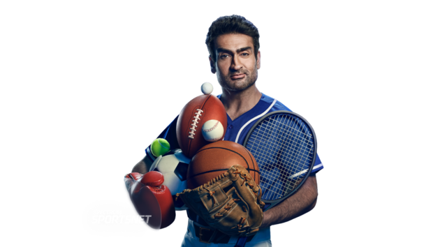 Man holding multiple sports balls surrounded by logos including NBC Sports, YES Network, FanDuel Sports Network, and Spectrum SportsNet.